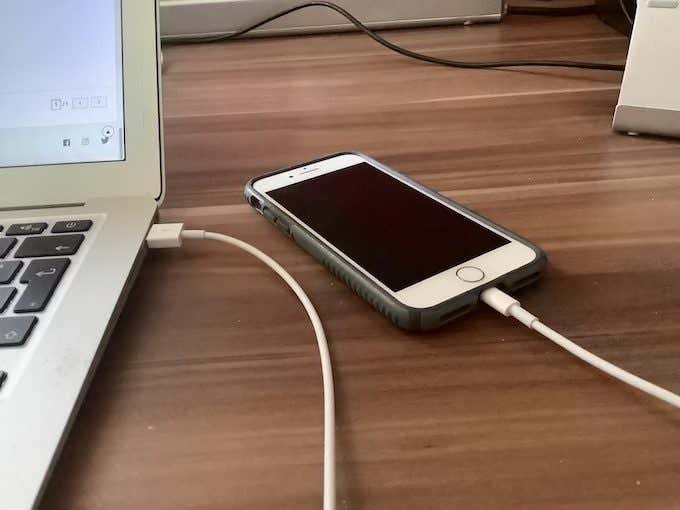 iPhone plugged into a Mac laptop