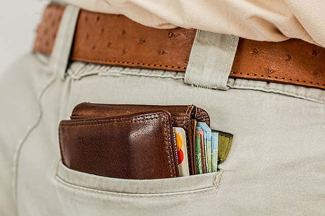 Bulky wallet sticking out of someone's back pocket