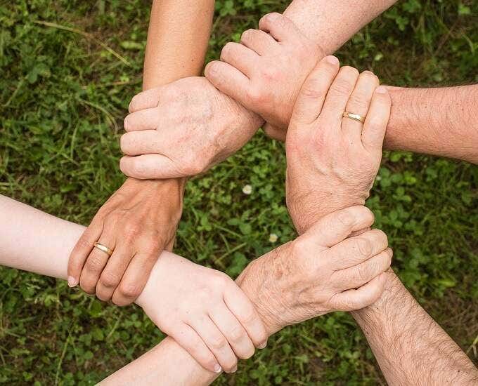 Image of a circle of hands holding each other by the wrist