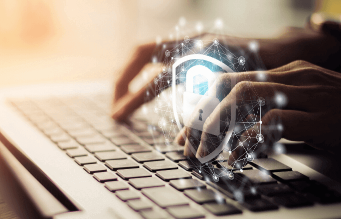 Hands typing on a computer with a padlock superimposed