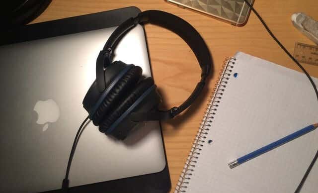 A pair of headphones plugged into a MacBook 