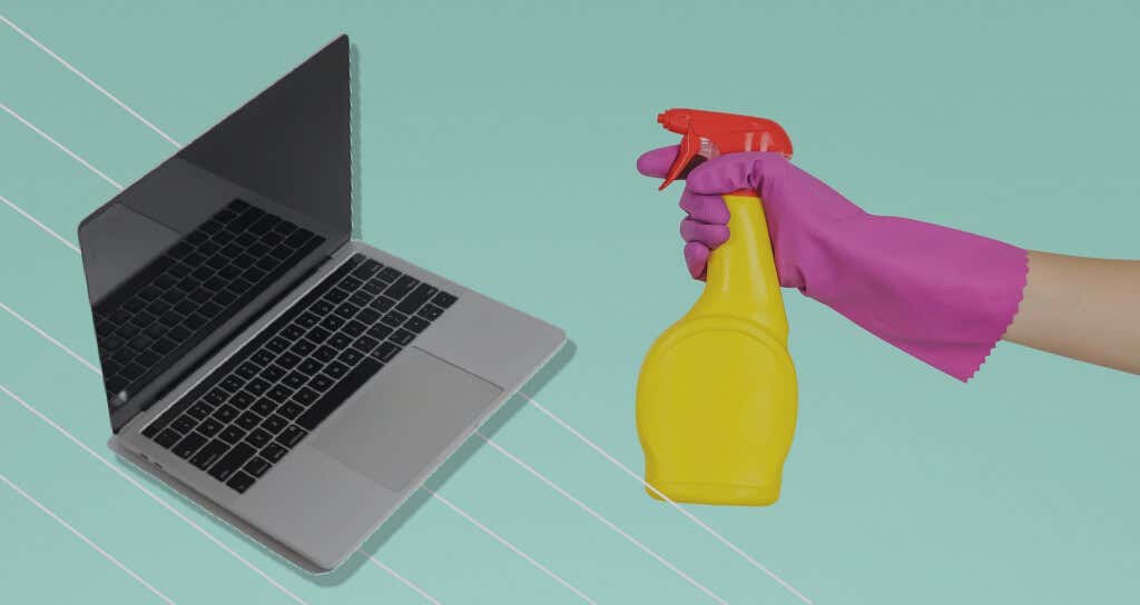 Someone holding a spray bottle and gloves next to a MacBook