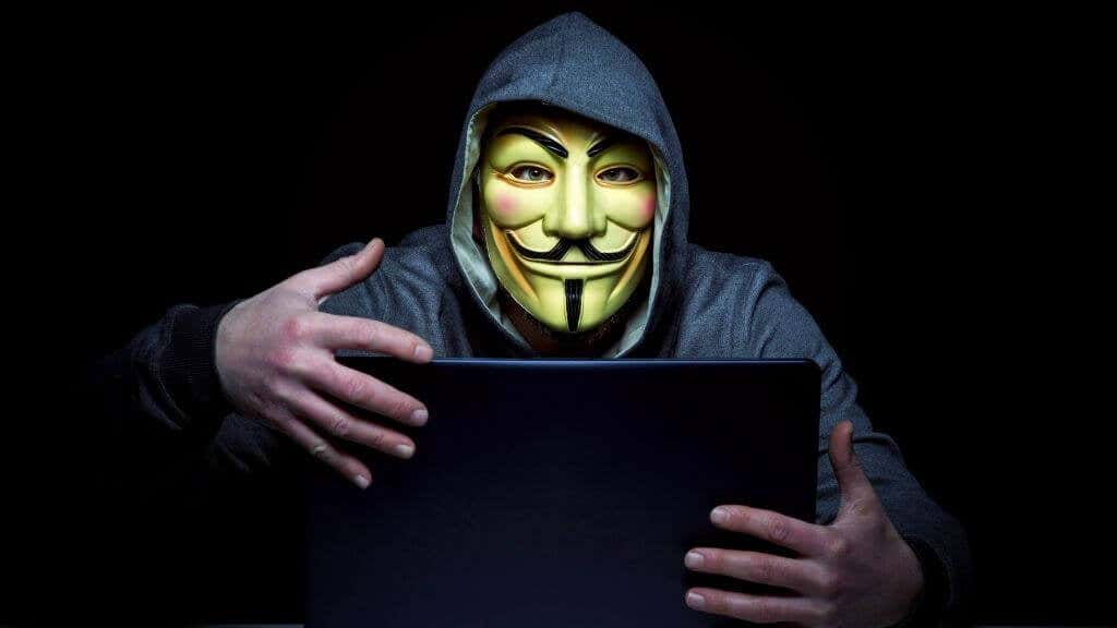 A hacker grabbing a laptop