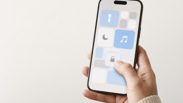Hand holding a smartphone with a grid of app icons; a lock icon tile is highlighted and being tapped by a finger.