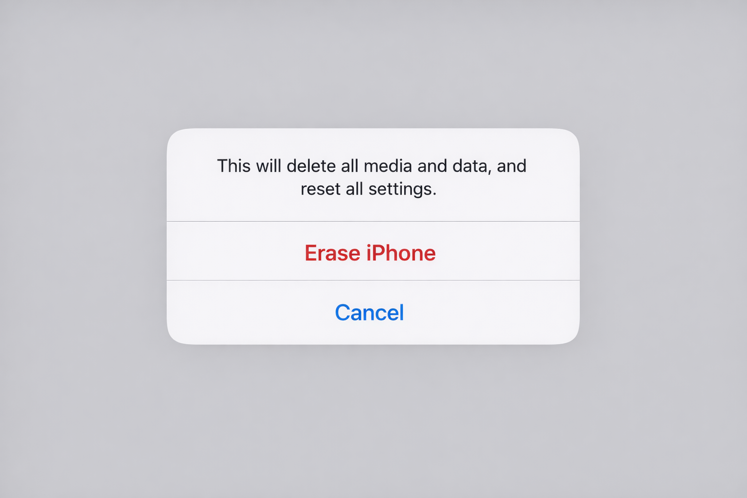 iPhone showing the "This will delete all media and data, and cannot be undone" confirmation alert before the erase begins