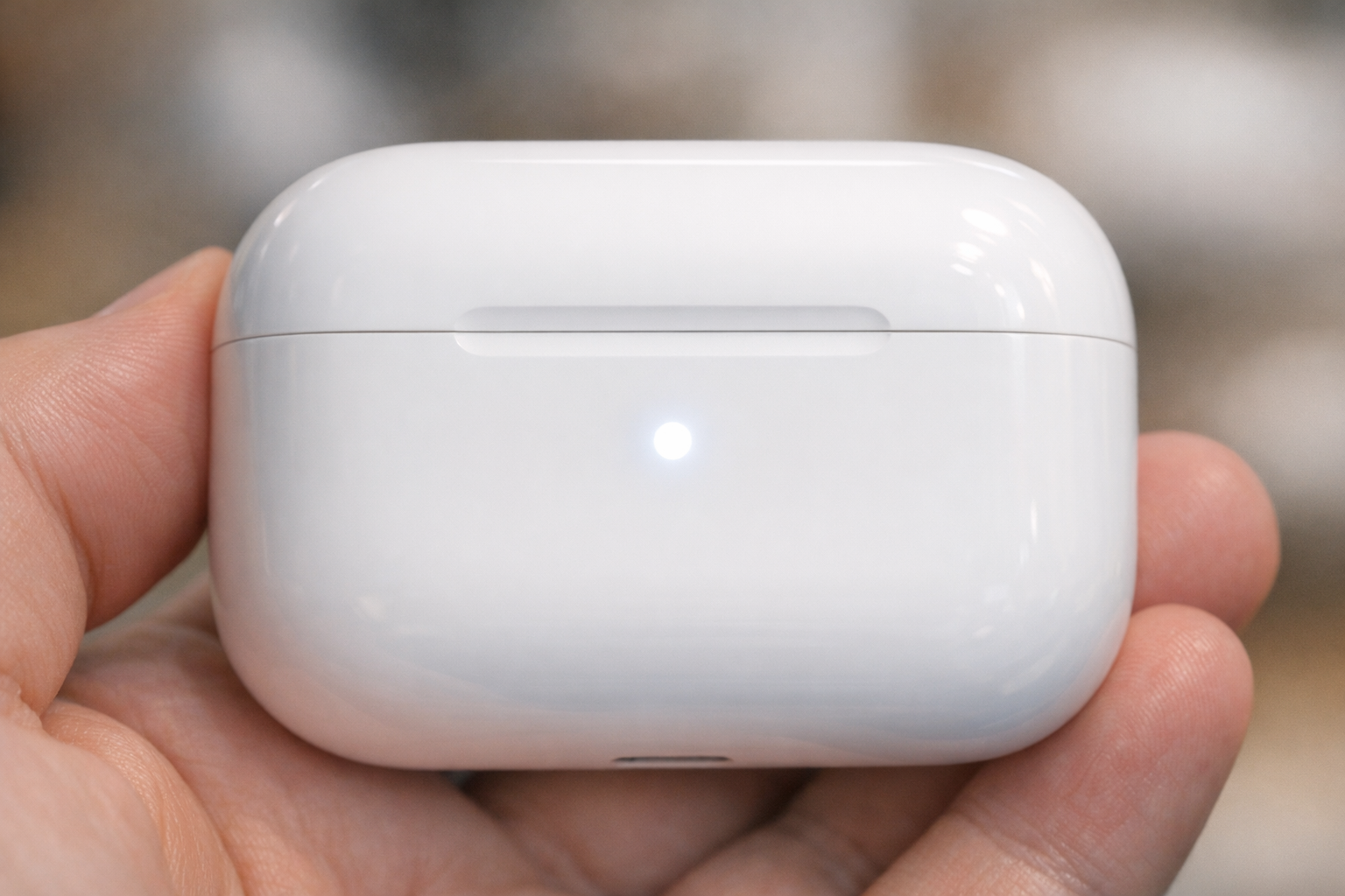 Close-up of the LED indicator on an AirPods case flashing white, indicating pairing mode is active